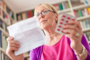 seniorka czyta ulotkę leku