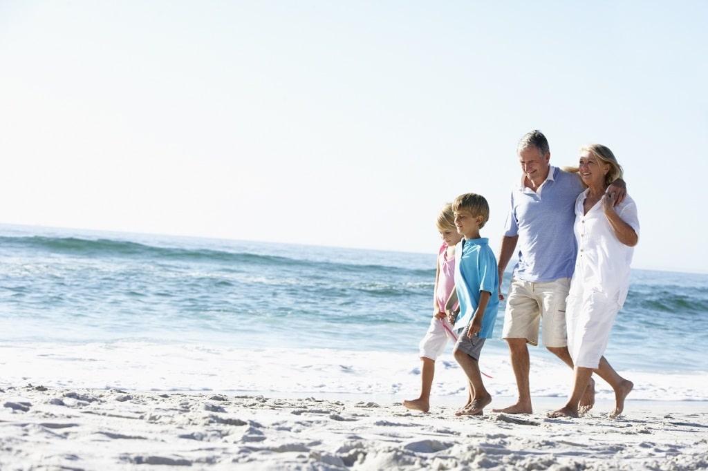 Grandparents and Grandchildren Walking Along Beach