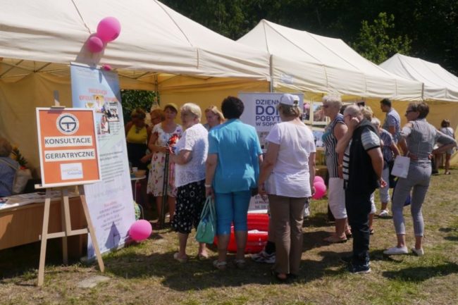 Stoiska z ofertami i poradami dla seniorów podczas festynu na boisku przy Domu Pomocy Społecznej w Sopocie